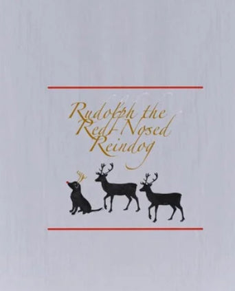 Three black reindeer, the leftmost with a red nose, are shown on a light gray background. Elegant gold text above reads "Rudolph The Reindog Tea Towel" by Rustic County.