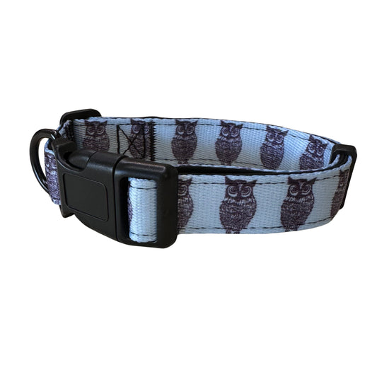 Introducing the Rustic County Hooty Owl Adjustable Pet Collar: a comfortable, durable collar in light blue with black owl illustrations, a sturdy black plastic buckle, metal D-ring, and adjustable strap—ideal for any fashionable pup!.