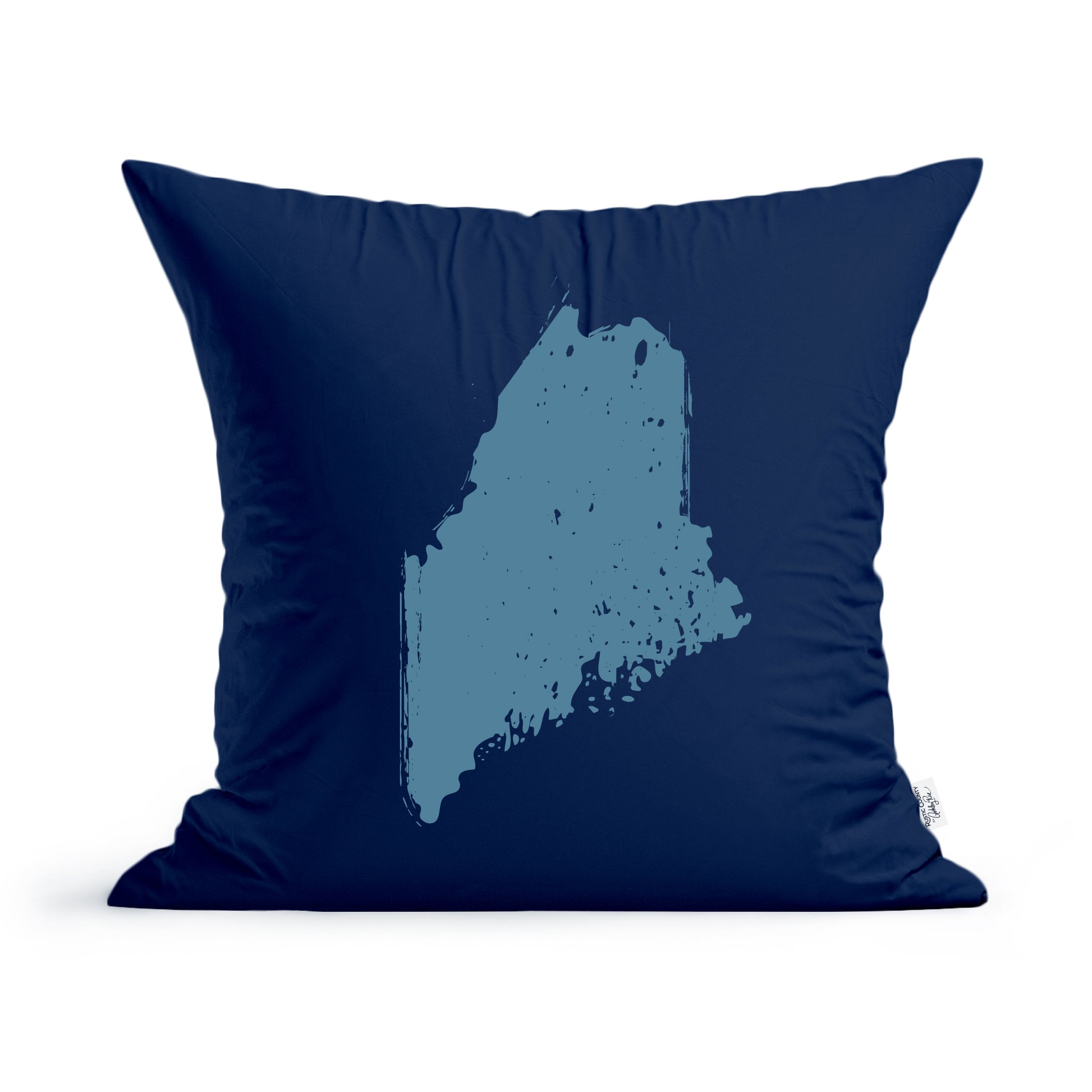 A Rustic County navy blue square State of Maine Pillow featuring a light blue silhouette of the state of Maine in a distressed print style, with a fluffy texture visible around the edges and a machine washable cotton pillow cover.