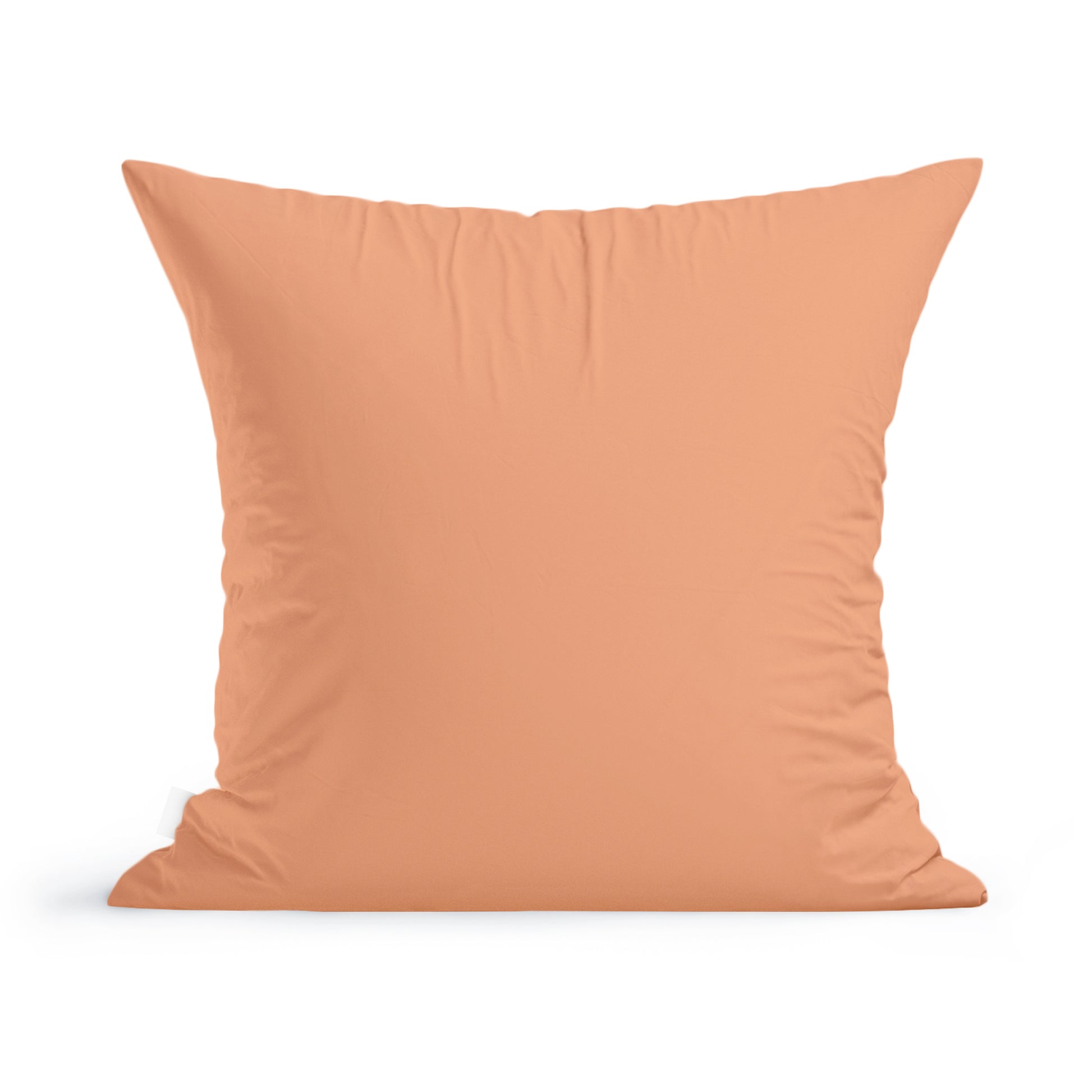 A plain peach-colored square Sunflowers Pillow by Rustic County on a living room sofa.