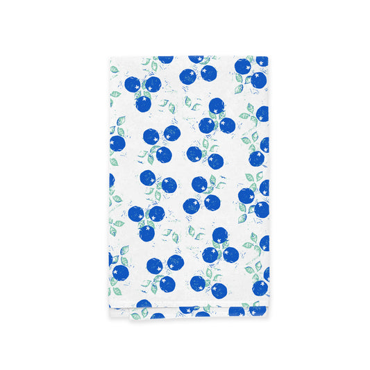 A Wild Blueberry Kitchen Tea Towel with a decorative cover featuring a pattern of blue apples and green leaves on an ultra-absorbent, textured white background by Rustic County.