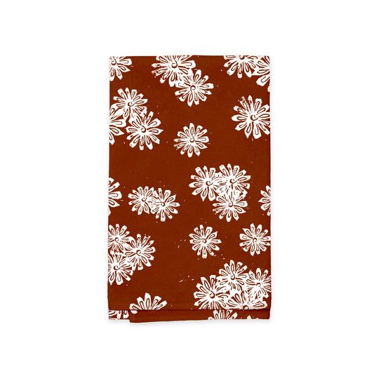 A book with a brown cover featuring a repeated white Rustic County Wild Daisies Kitchen Tea Towel pattern.